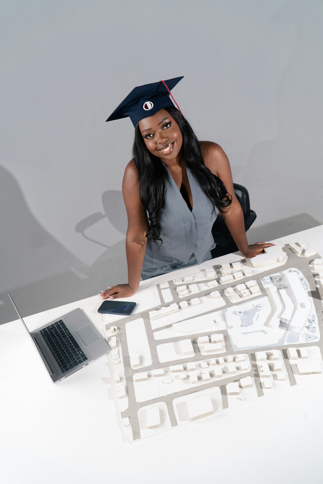 smiling-graduate-woman-with-architectural-model-and-laptop-b-u51kvmnm